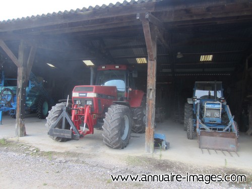 Tracteurs rouge et bleu dans un hangar agricole